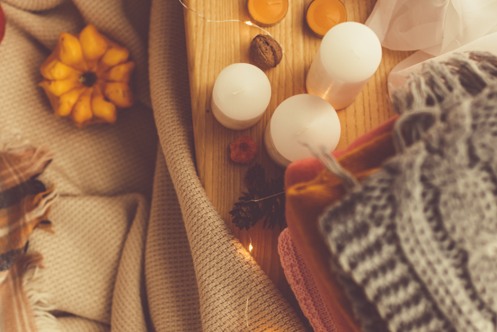 image of fall decor including mini pumpkins candles and warm fuzzy blankets