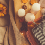 October newsletter image of fall decor including mini pumpkins candles and warm fuzzy blankets