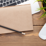 Image of laptop and notepad on a desk