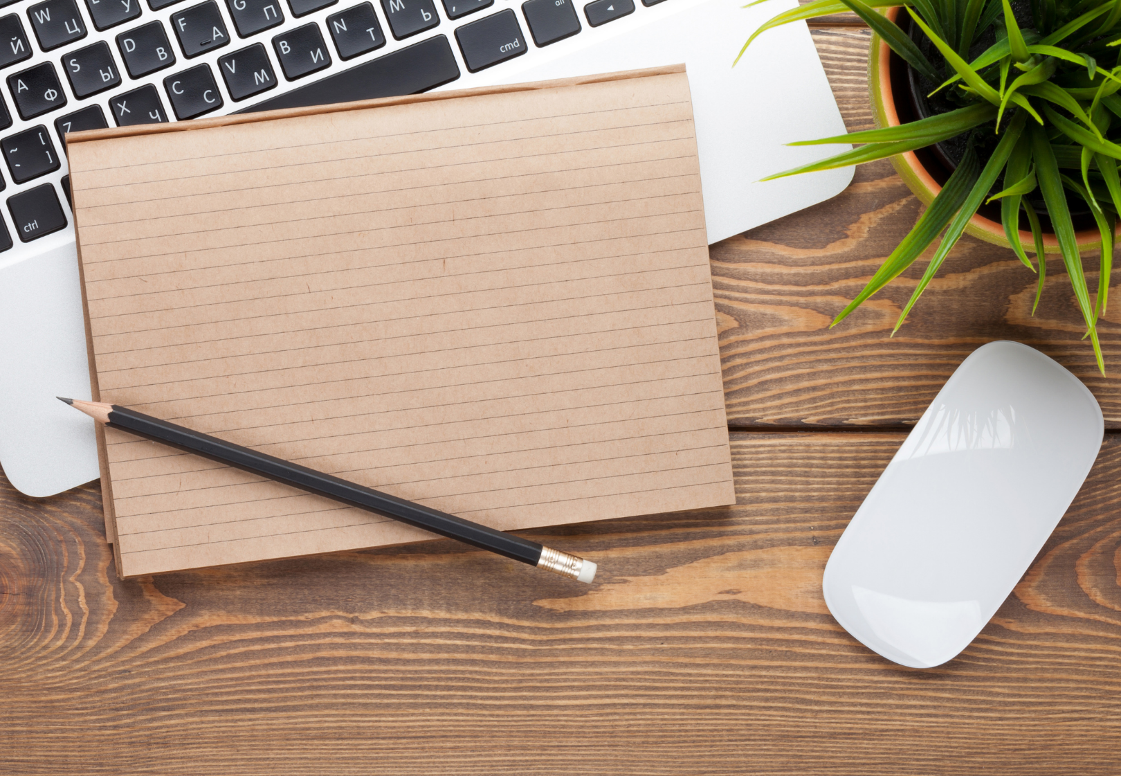 Image of laptop and notepad on a desk