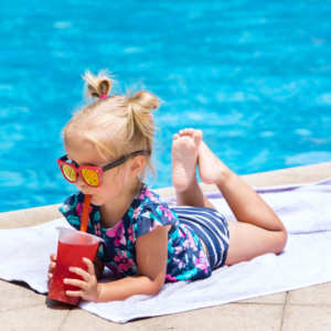 image of a young girl relaxing by the pool with a refreshing summer smoothie
