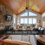 image of a cozy living room with a stone fireplace and a view of the mountains